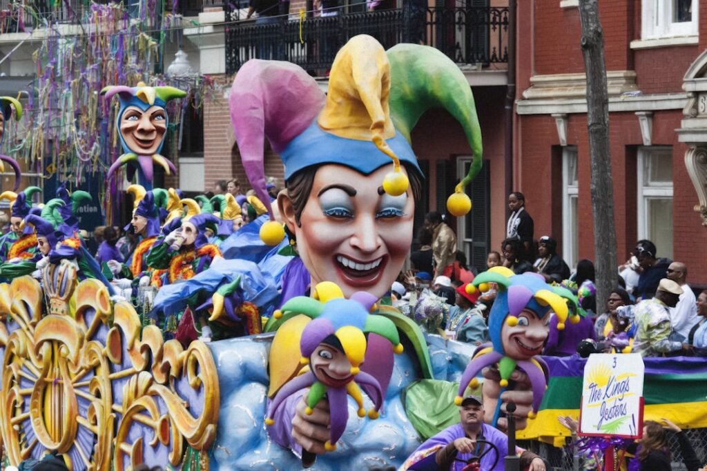 Mardi Gras 2026 Date: Complete Guide to Fat Tuesday, Parade Schedules & Planning Tips Crowds lining St. Charles Avenue in New Orleans watching a Mardi Gras parade float pass by, people in purple green and gold costumes catching throws
